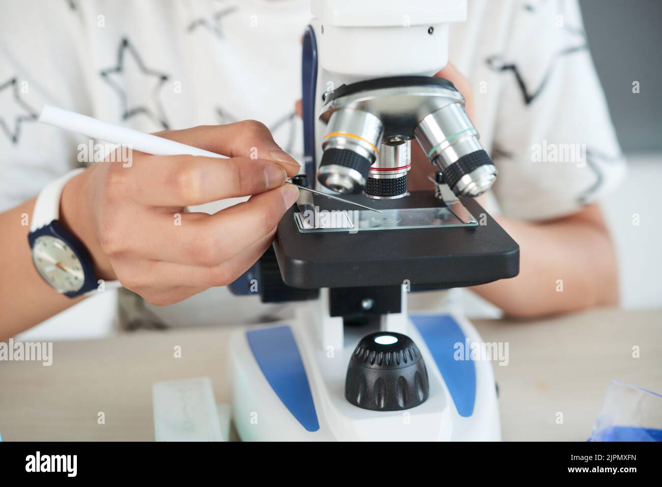 Closeup shot of unrecognizable boy using cover slip while examining