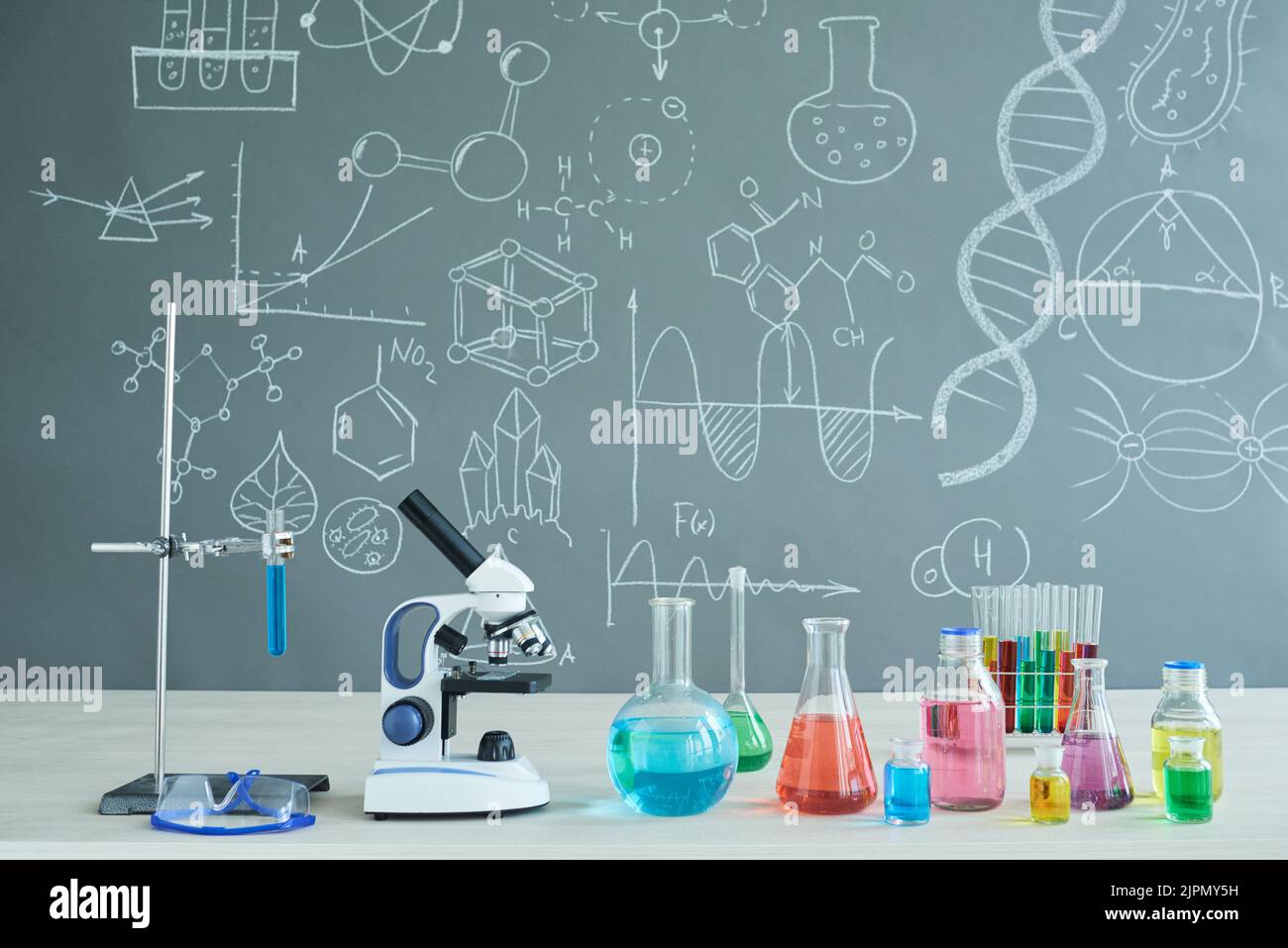 Interior of modern chemistry classroom desk with microscope and