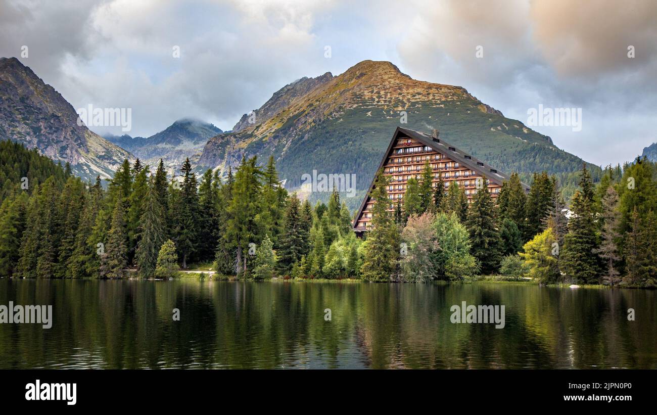 The beautiful view of traditional mountain hotel mirroring on surface of Strbske pleso lake, Vysoke Tatry, High Tatras, Slovakia. Amazing mountain lan Stock Photo