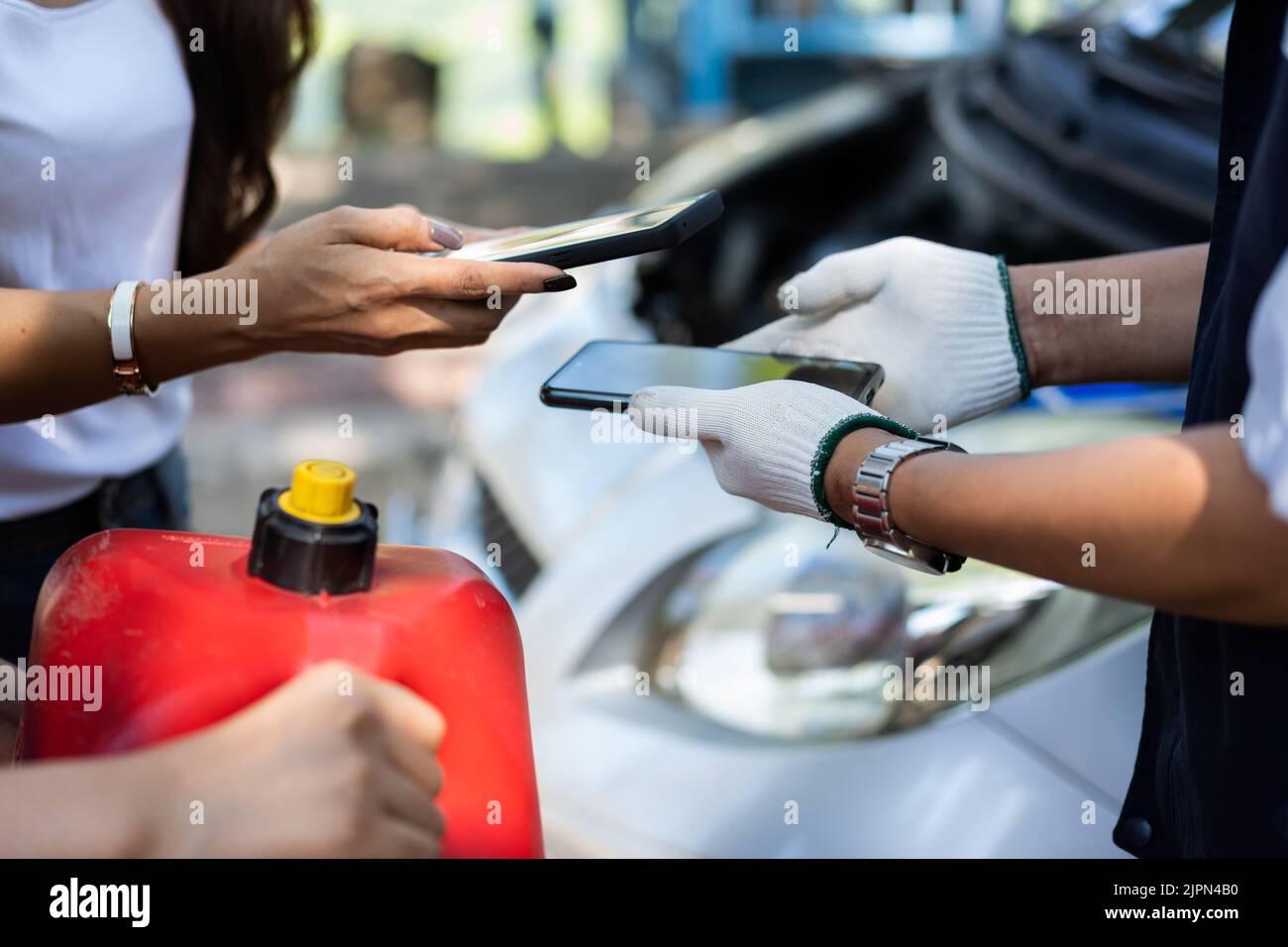 Asian women get contact numbers from auto mechanics after fixing the car engine problem and QR code scan to pay for gas after running out of fuel on t Stock Photo