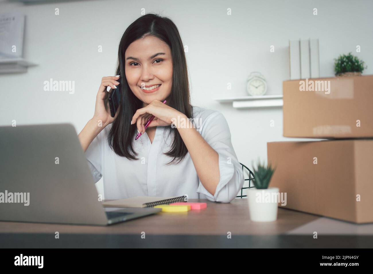 Happy young Asian woman entrepreneur, talk with a supplier and Smile for sale success of online shopping store at home office, Concept of the merchant Stock Photo