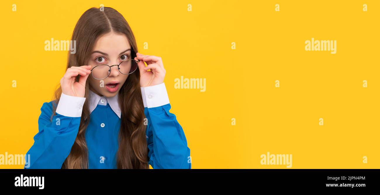 Just curious. Curious girl in eyeglasses. Nerdy-looking kid yellow background. Back to school. Child face, horizontal poster, teenager girl isolated Stock Photo