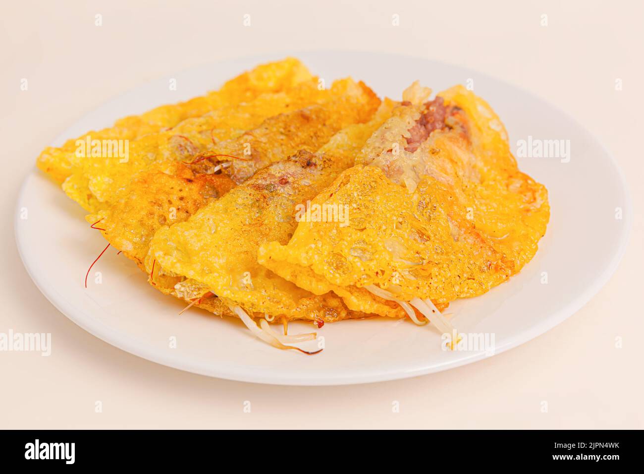 Banh xeo, Vietnamese Crêpes or Pancakes with pork, shrimp, onions, beasn sprouts inside, Vietnamese food isolated on white background. close-up Stock Photo