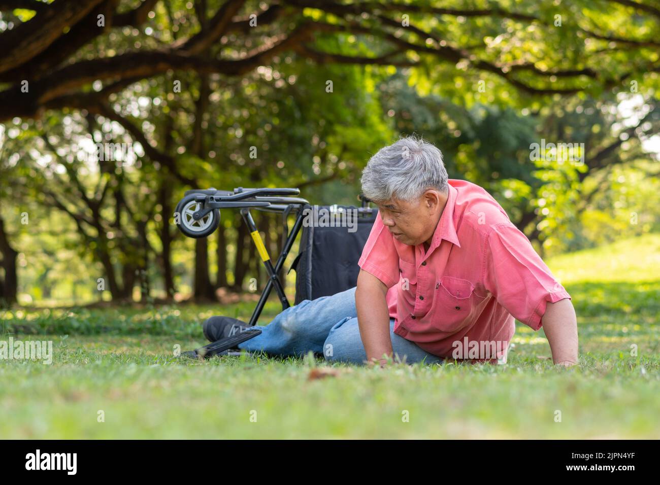 Asian senior man falling down from wheelchair on lying floor after