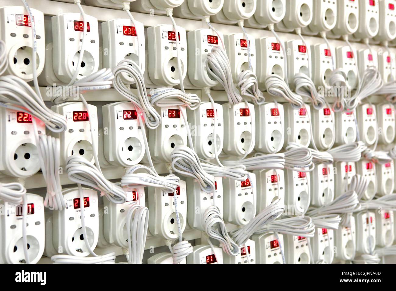 Quality control of electronic devices at the stand. Manufacture of sockets volt control and quality control. Lots of flashing electrical devices Stock Photo