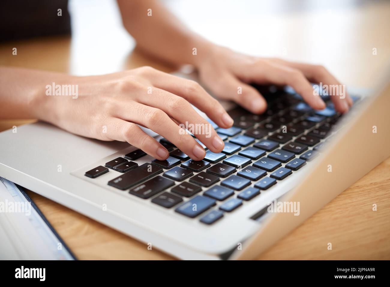 Hands of woman working on laptop on her table Stock Photo