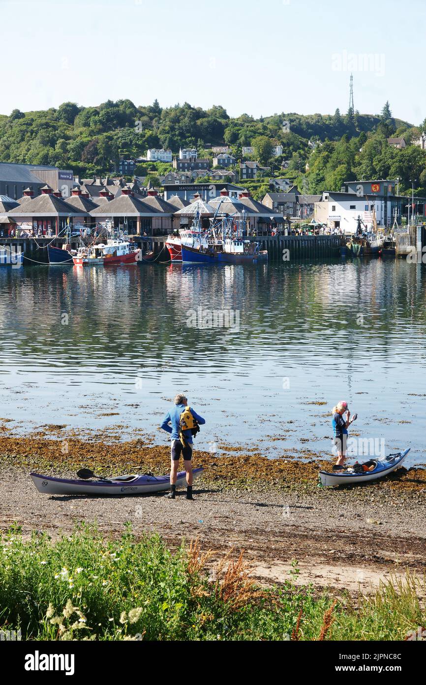 A pair of sea kayakers preparing to launch from the beach at Oban, Scotland. Stock Photo