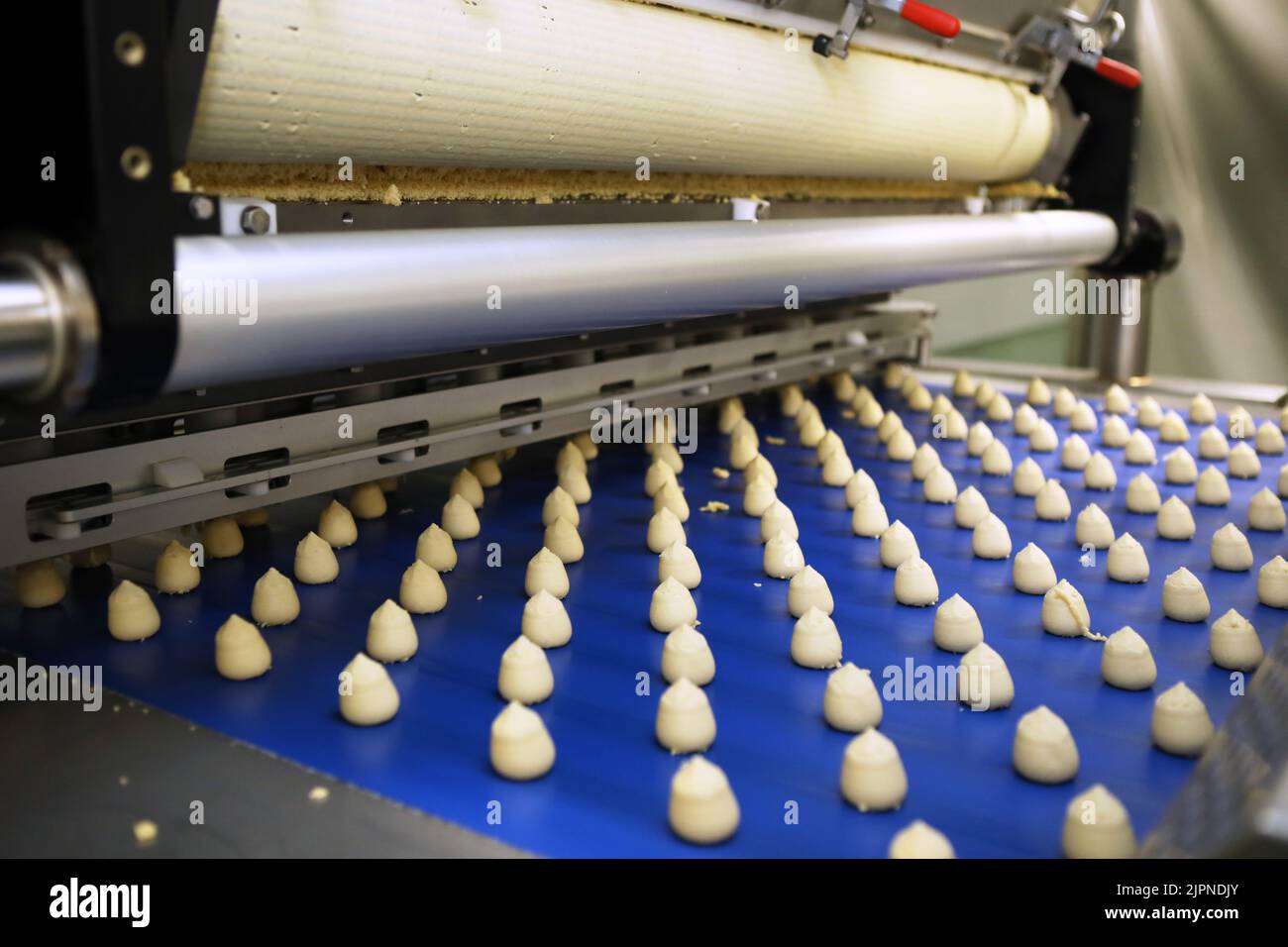 Controlling the work of huge conveyor machine producing spice cakes at the confectionary plant. Cookie production line. Innovative biscuit production. Stock Photo