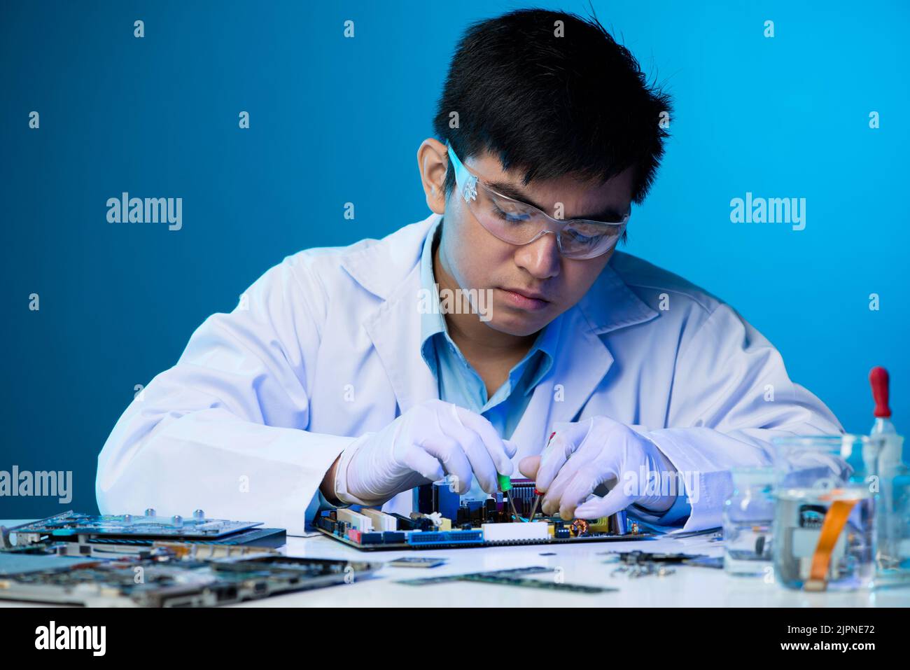 Young Vietnamese engineer working with electronic components Stock Photo