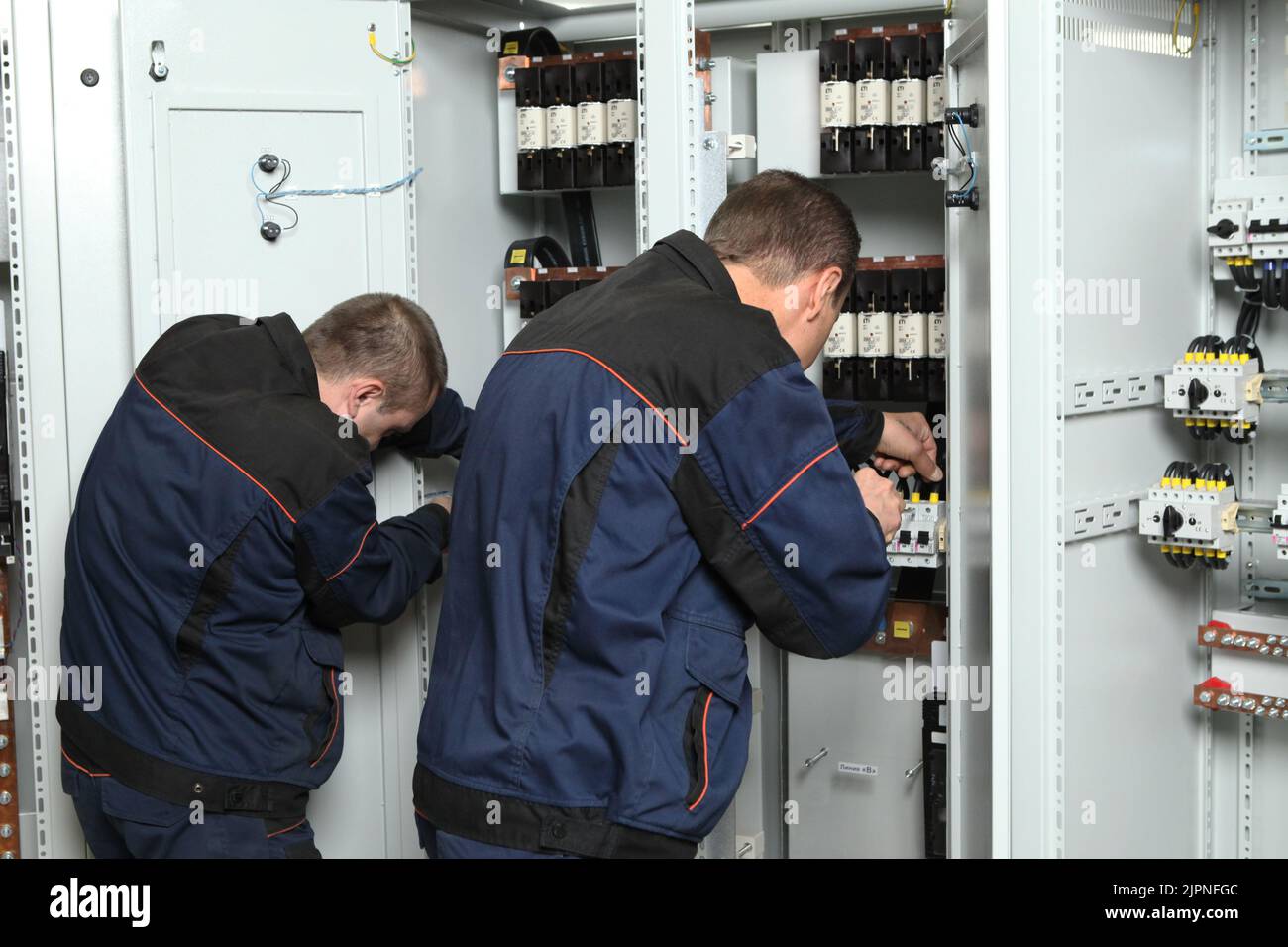 Electrician engineer work tester measuring voltage and current of power electric line in electical cabinet control.and wires on relay protection syste Stock Photo