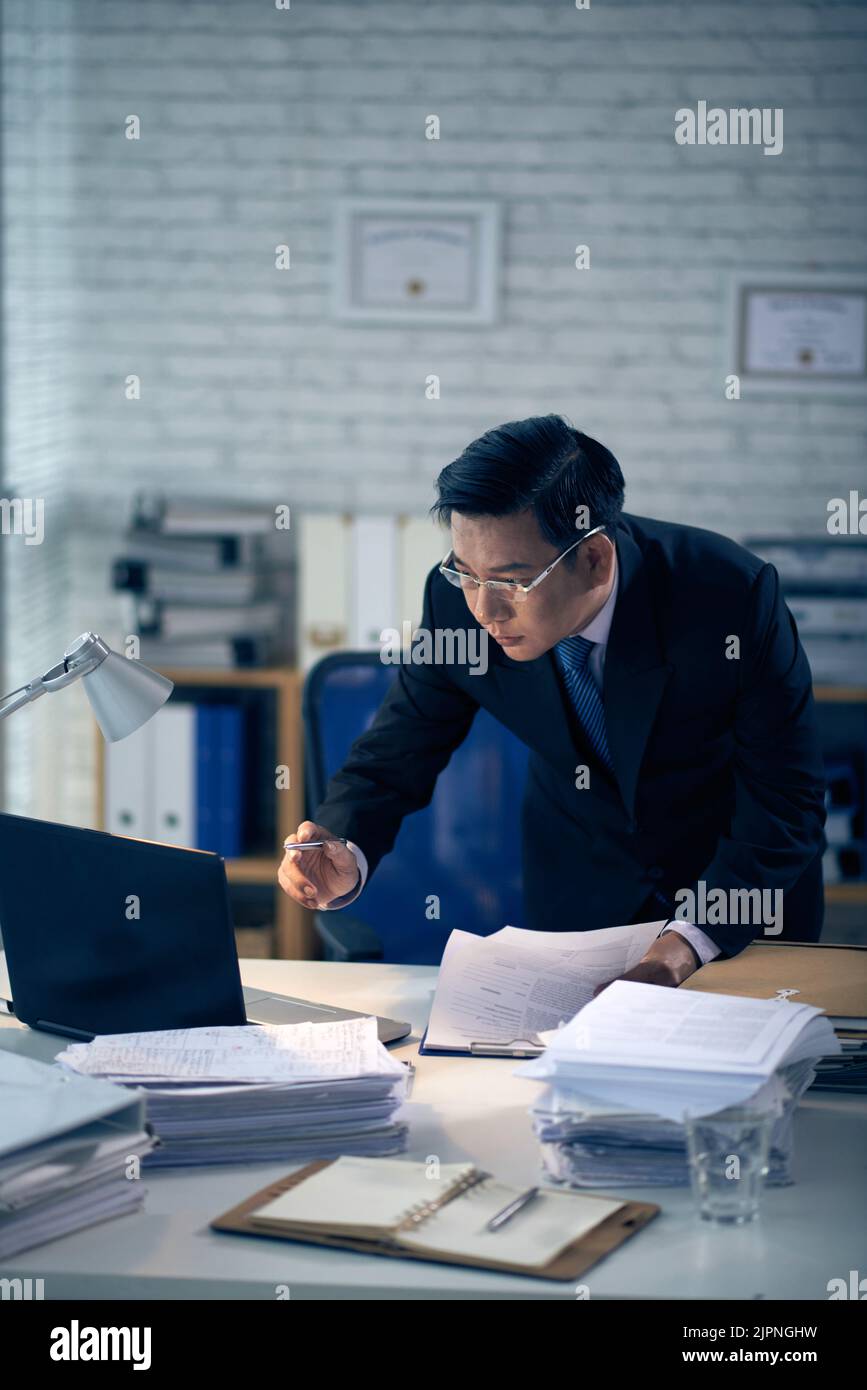 Vietnamese professional lawyer reading document on laptop screen Stock Photo