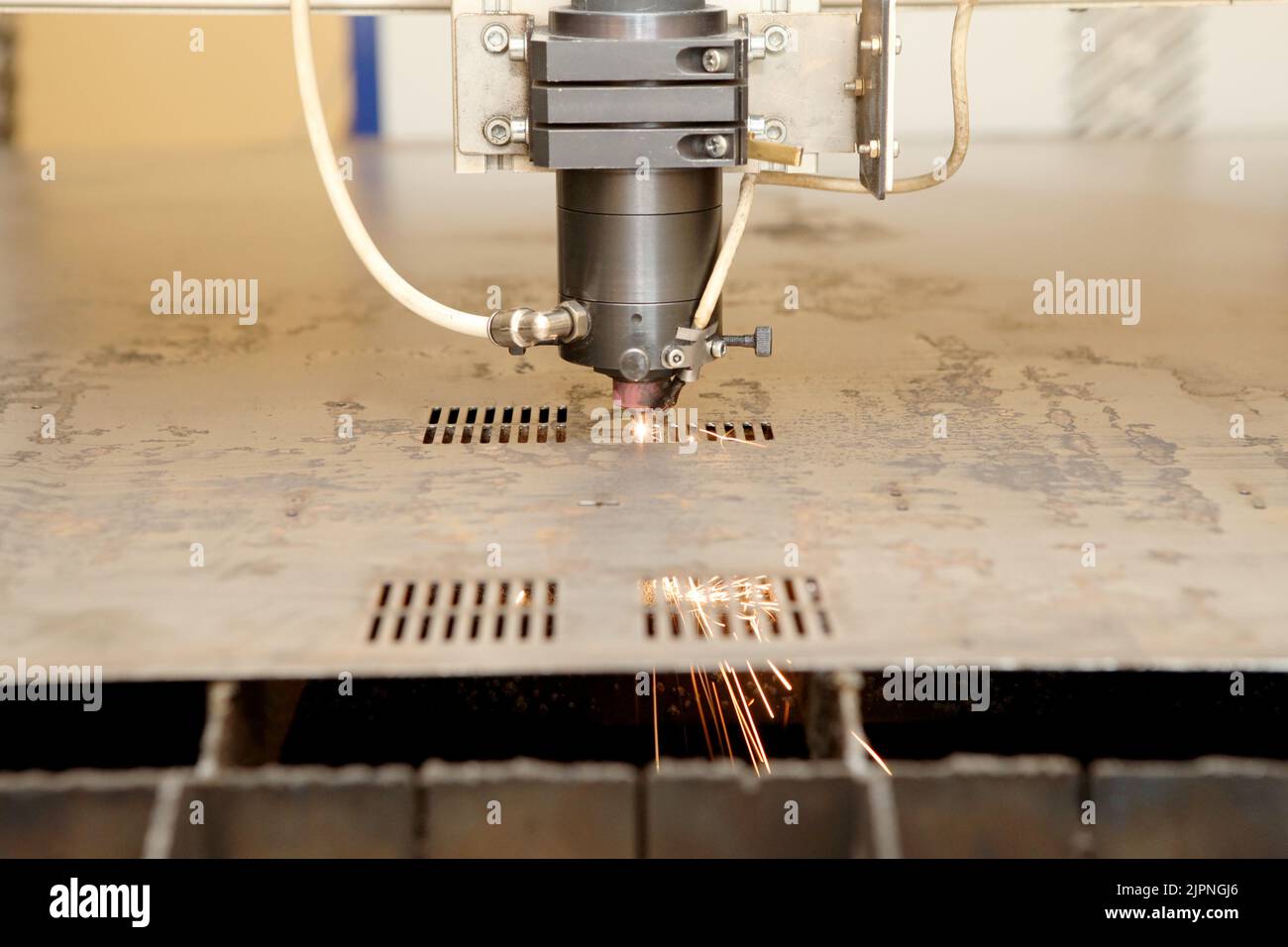 Plasma cutting CNC machine cuts metal material with sparks, industry