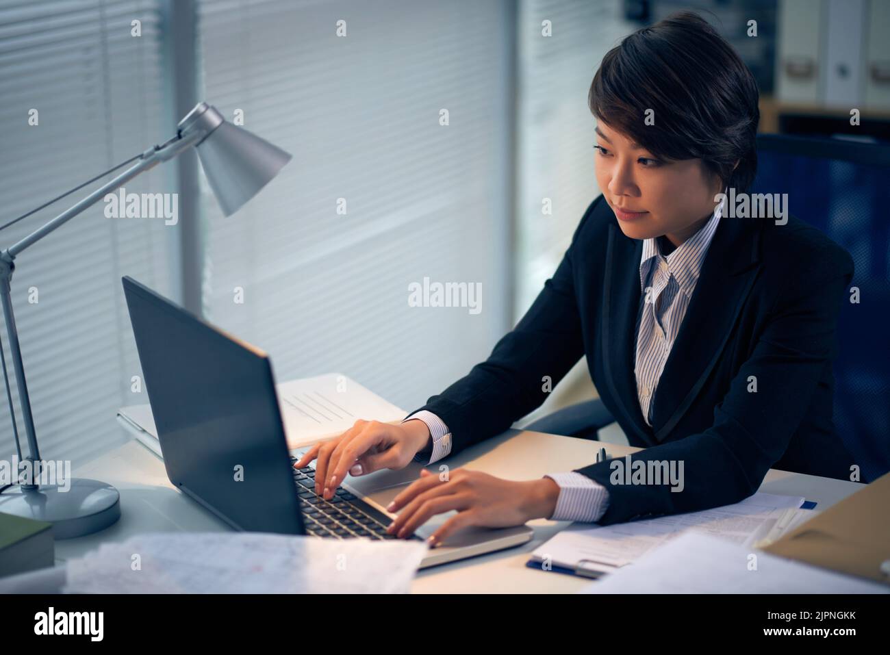 Female intern lawyer working on laptop in office Stock Photo