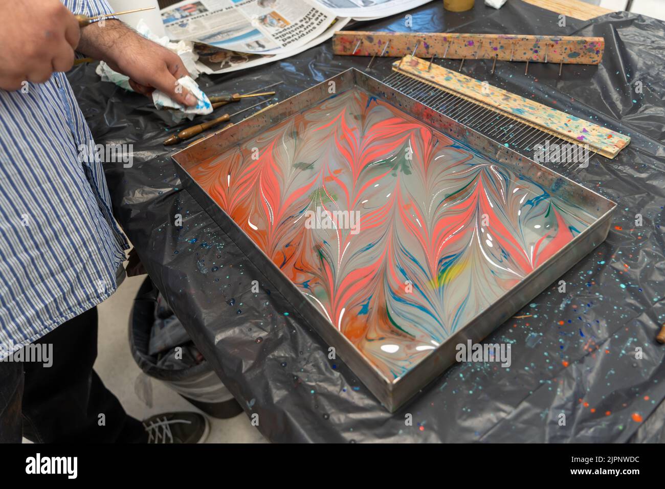 Artist Tugay Yalcin teaches beginners the art of paper marbling, a Turkish discipline known as ebru, at Fenham Library, Newcastle upon Tyne, UK. Stock Photo