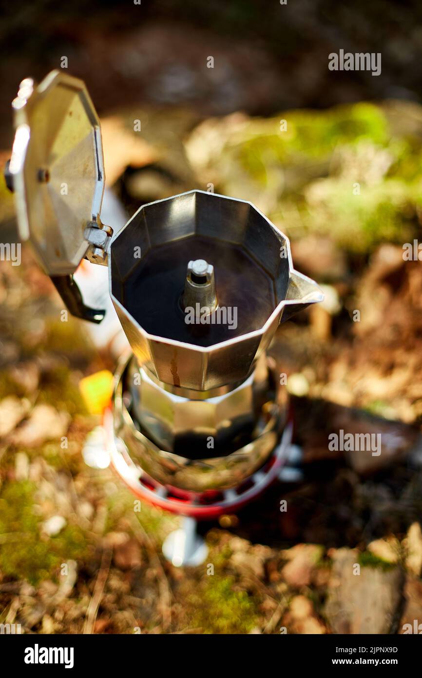 https://c8.alamy.com/comp/2JPNX9D/making-camping-coffee-from-a-geyser-coffee-maker-on-a-gas-burner-autumn-outdoor-male-prepares-coffee-outdoors-travel-activity-for-relaxing-bushcr-2JPNX9D.jpg