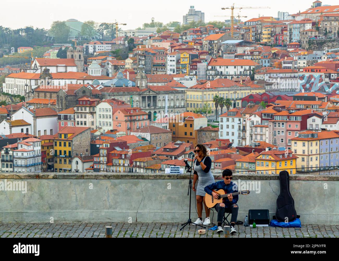 Buskers performing for tourists on a hillside overlooking the centre of Porto a major city in northern Portugal. Stock Photo