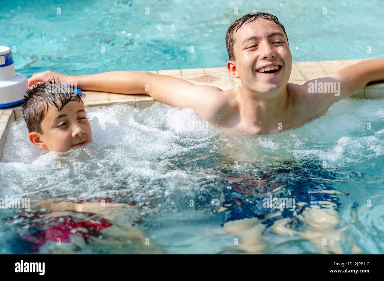 Brothers relax together in a jacuzzi which is attached to an outdoor