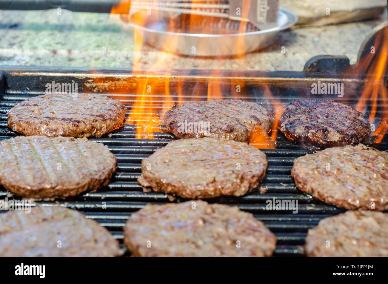 Beef burgers cooking on a barbecue Stock Photo Alamy