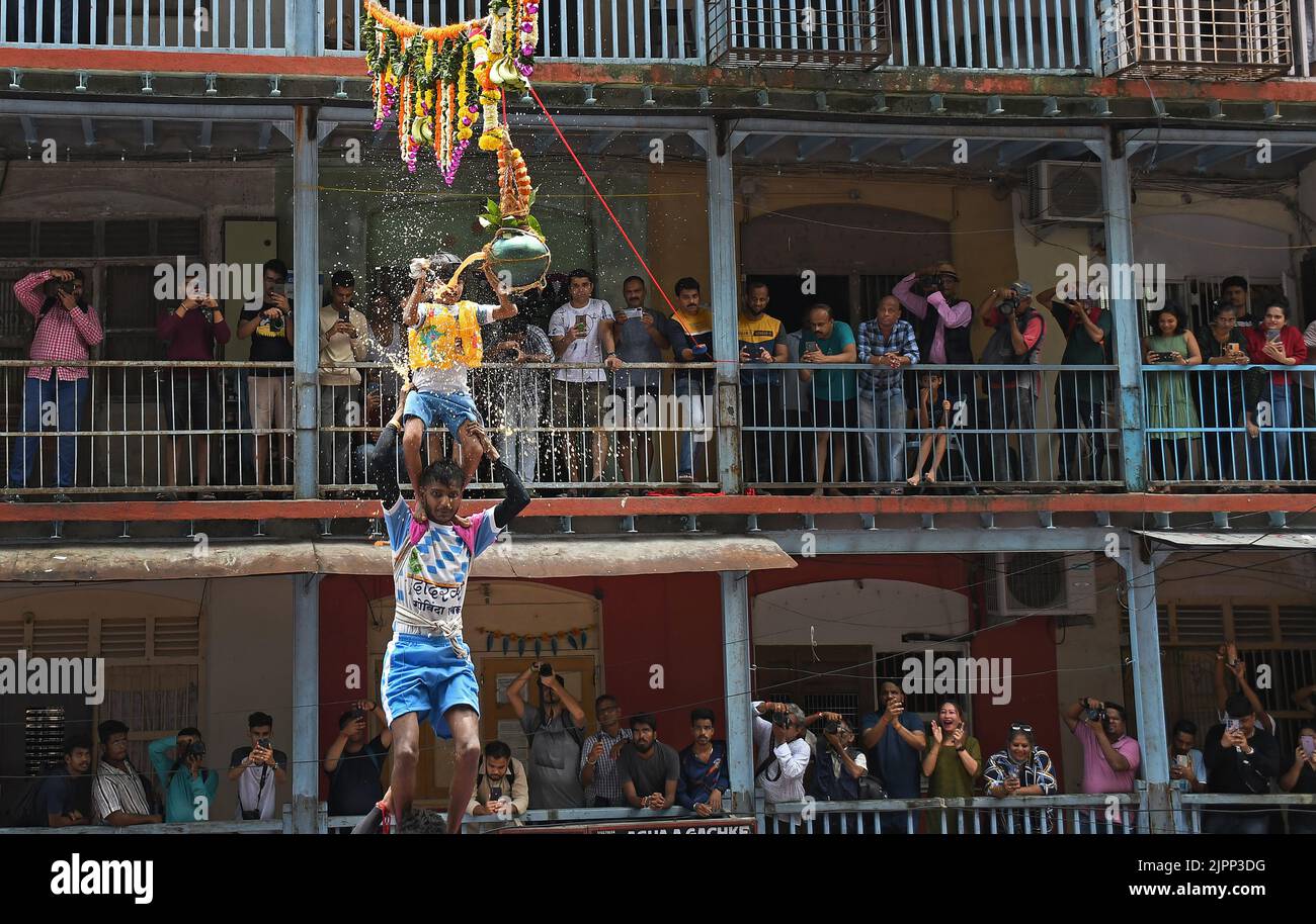 Mumbai, India. 19th Aug, 2022. A Hindu devotee standing on the top of a human pyramid breaks dahi handi (earthen pot filled with curd) during Janmashtami festival in Mumbai. Janmashtami is celebrated to mark the birth of Lord Krishna. Hindu devotees gather on the streets and form acrobatic pyramids to break dahi handi (earthen pot filled with curd) celebrating the occasion. (Photo by Ashish Vaishnav/SOPA Images/Sipa USA) Credit: Sipa USA/Alamy Live News Stock Photo