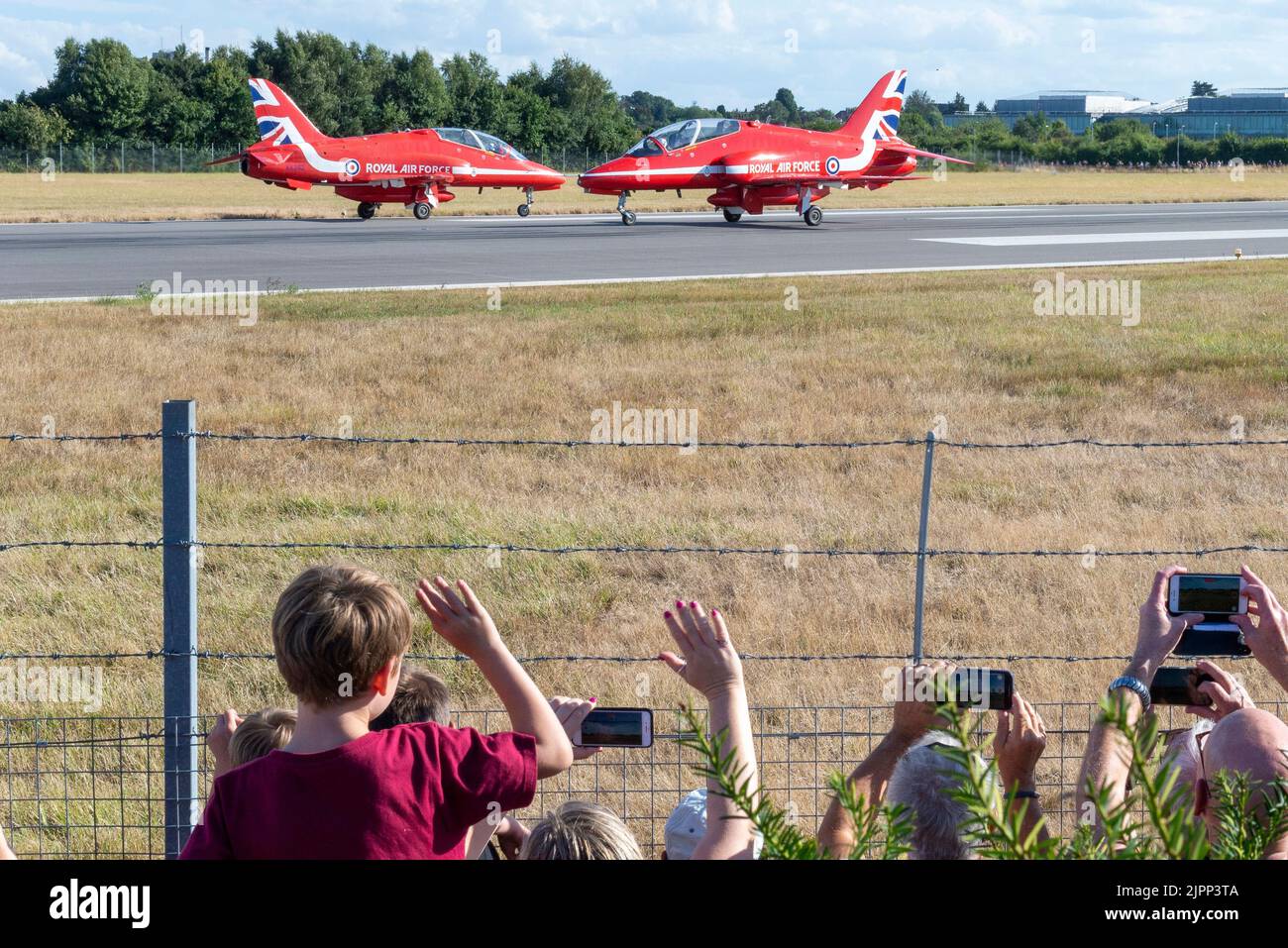 London Southend Airport, Essex, UK. 19th Aug, 2022. The RAF’s Red Arrows are using the civilian airport to operate from for this weekend’s airshows at Eastbourne and Folkestone. The Red Arrows have arrived this evening, arriving in their famous arrow formation before breaking to land. Many people have come out to see them, lining the fences Stock Photo