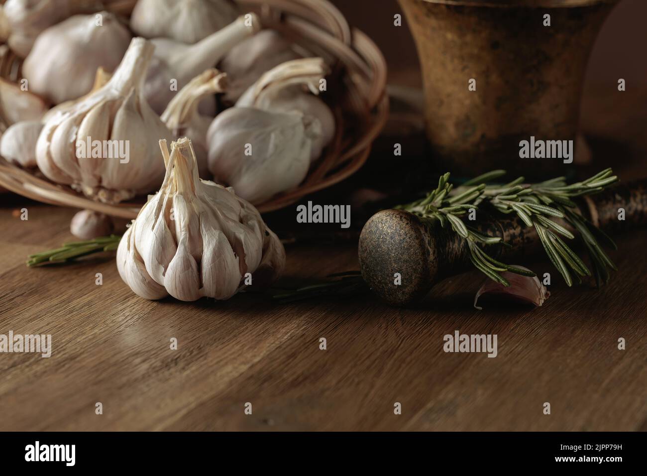 Garlic bulbs and rosemary on an old wooden table Stock Photo - Alamy