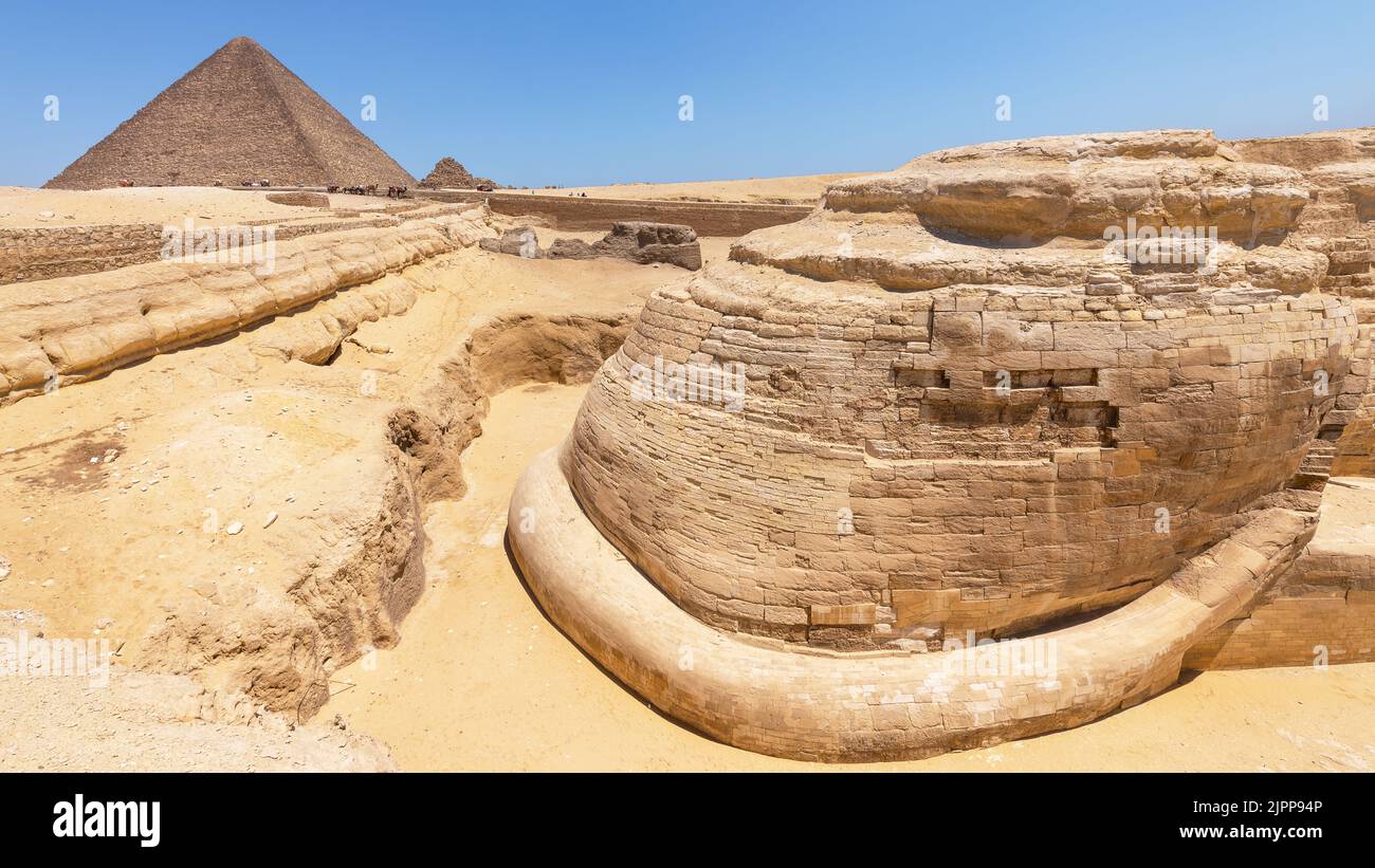 Giza, Egypt; August 14, 2022 - The tail of the sphinx and the pyramid of Cheops, Giza, Egypt. Stock Photo