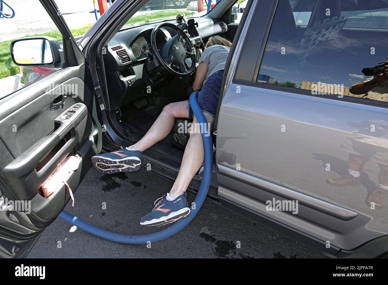 A woman vacuuming her car at a public car wash in Bend, Oregon. Stock Photo
