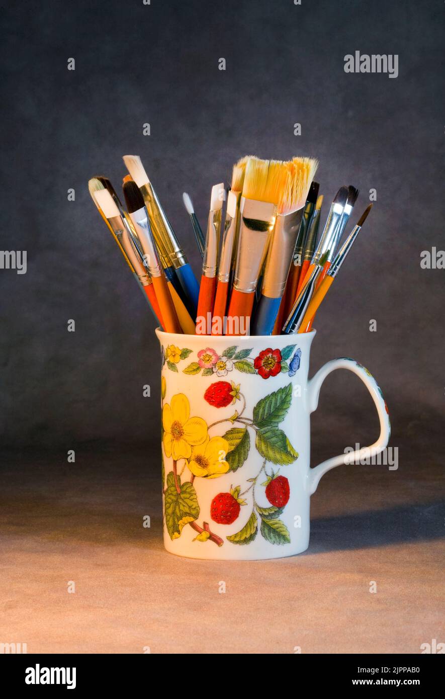 A cup filled with paint b rushes in an artists studio in Oregon. Stock Photo