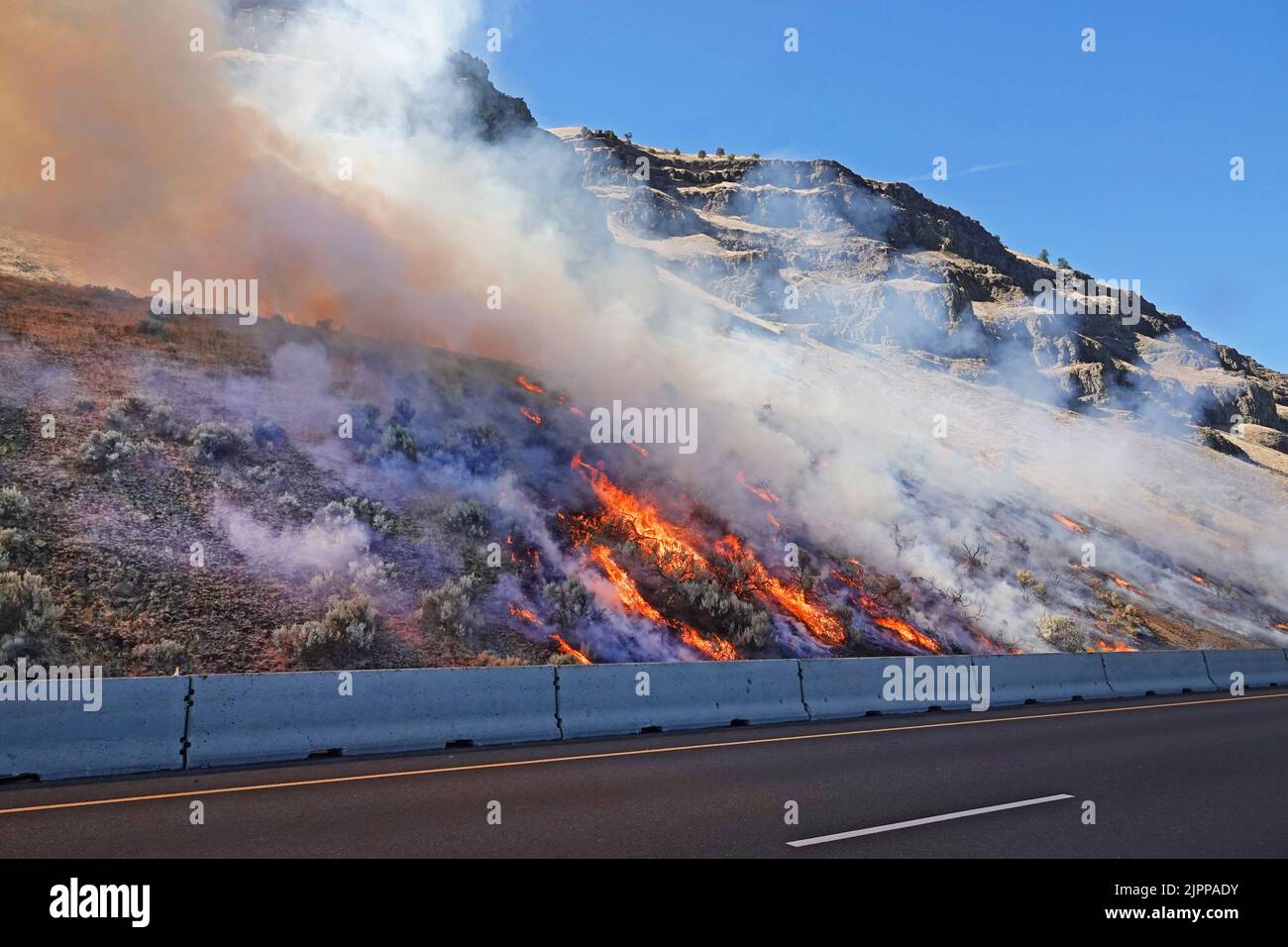 A roadside brush fire just starting on Interstate 84 near the town of Arlington, Oregon, during mid-august, 2022. Stock Photo