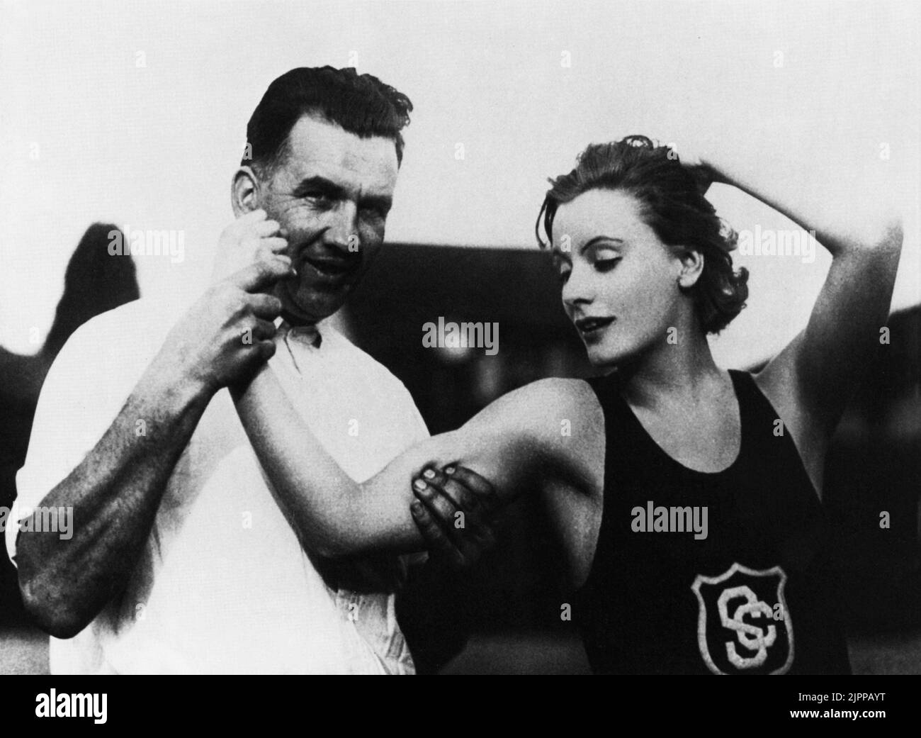 1925 , USA : The  movie actress  GRETA GARBO ( 1905 - 1990 ) in a pubblicity photo with the athletic theacher of University of Southern California   - MOVIE - CINEMA - portrait - ritratto  - muscoli - muscles - biceps - bicipiti - canottiera - braccio - arm - fitness   ----  Archivio GBB Stock Photo