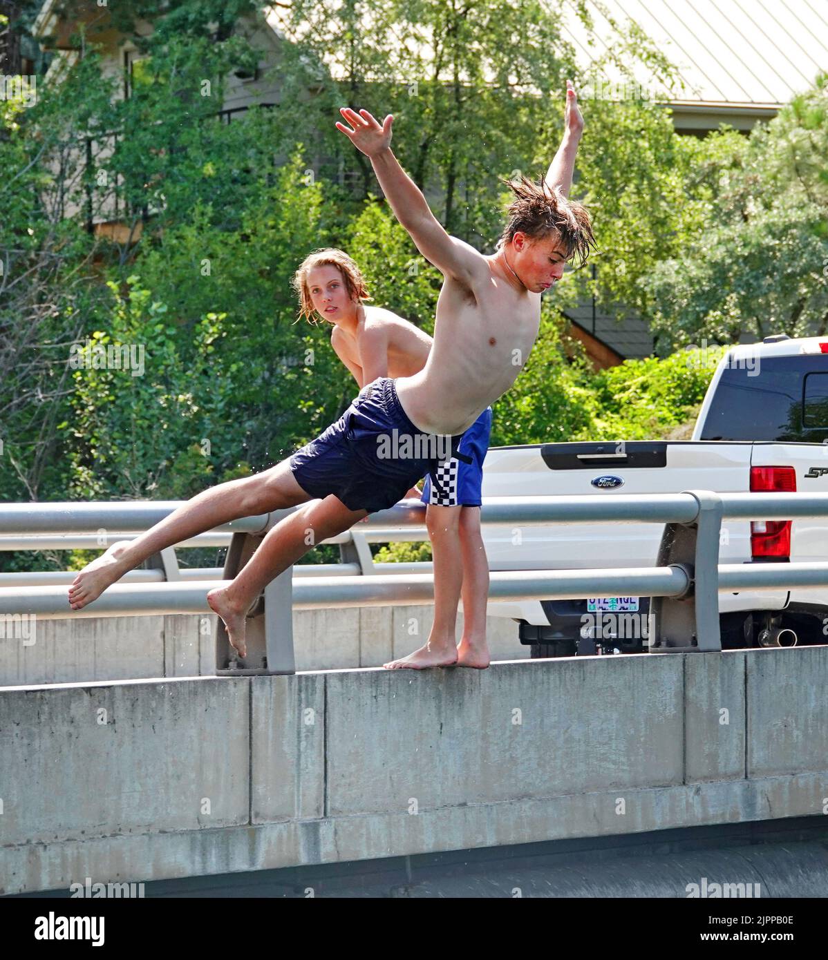 Young boys cool off by diving into  the Deschutes River in Bend, Oregon, trying to escape the 100 degree F heatwave that is sweeping the Pacific Northwest. Stock Photo