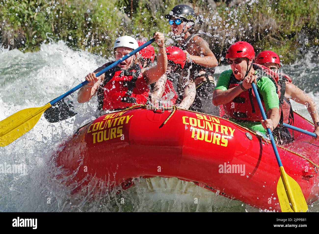 Whitewater rafters in a paddleboat enjoy the rapids of the upper Deschutes River in the Cascade Mountains near Bend, Oregon. Stock Photo