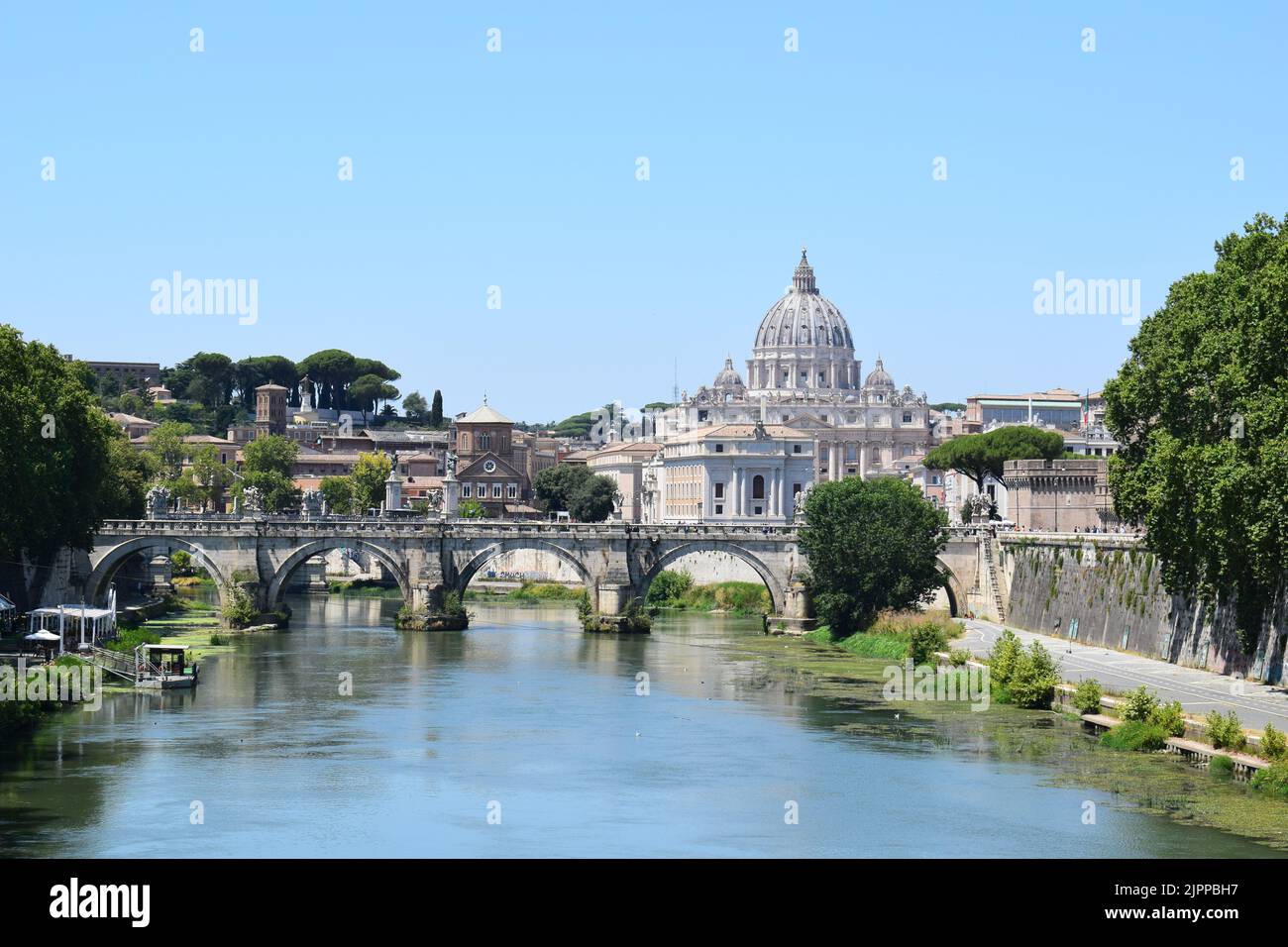 ROME, ITALY - JULY 21, 2022: View of River Tiber and Ponte Sant'Angelo Bridge. St Peter's Cathedral in the background. Stock Photo