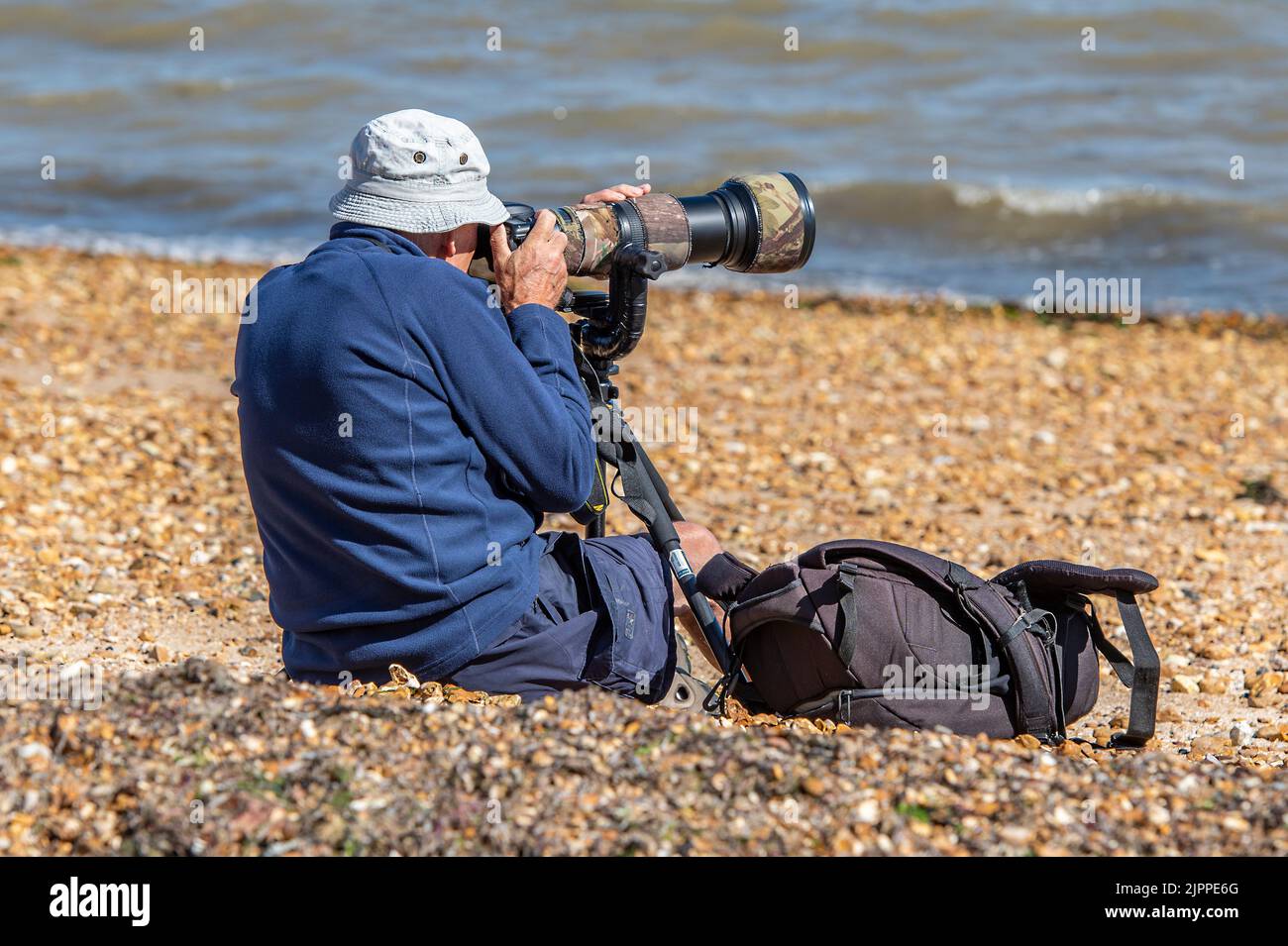 photographer using long telephoto lens taking pictures of yachts during the annual cowes week regatta on the isle of wight uk, photographer using lens Stock Photo