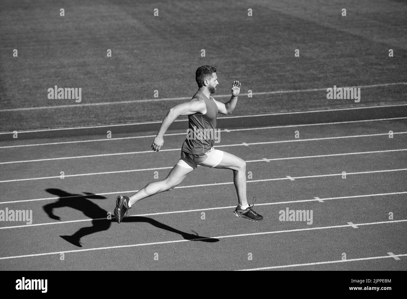 sportsman man in sportswear run fast sprinting on running track, energy