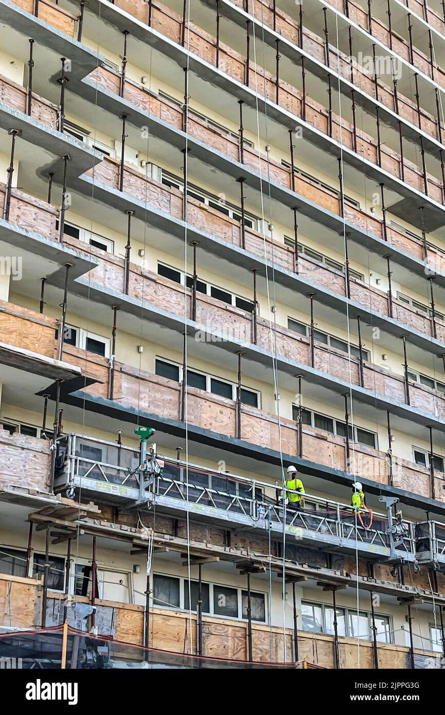 The decks of a high rise South Florida condo are boarded up with plywood as construction workers remodel the building. Stock Photo