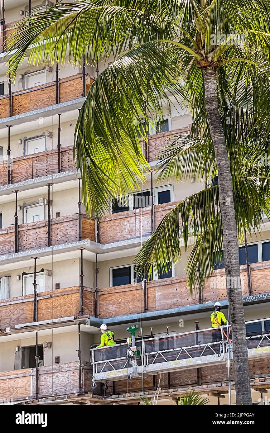 The decks of a high rise South Florida condo are boarded up with plywood as construction workers remodel the building. Stock Photo