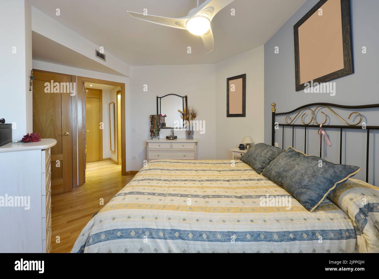 Ugly decorated bedroom with metal headboard, light furniture and ...