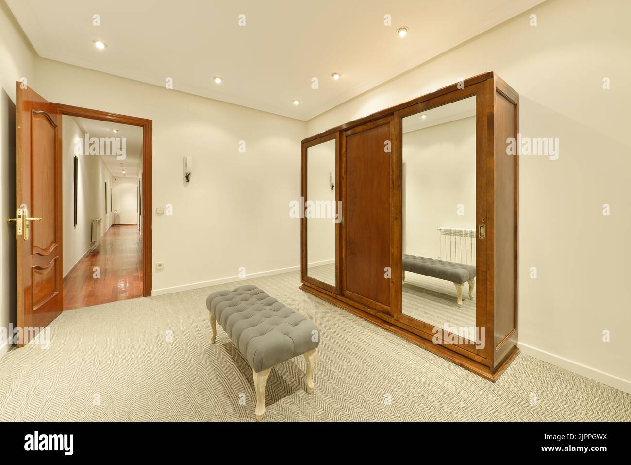 Dressing room with vintagestyle wooden wardrobe with sliding mirror