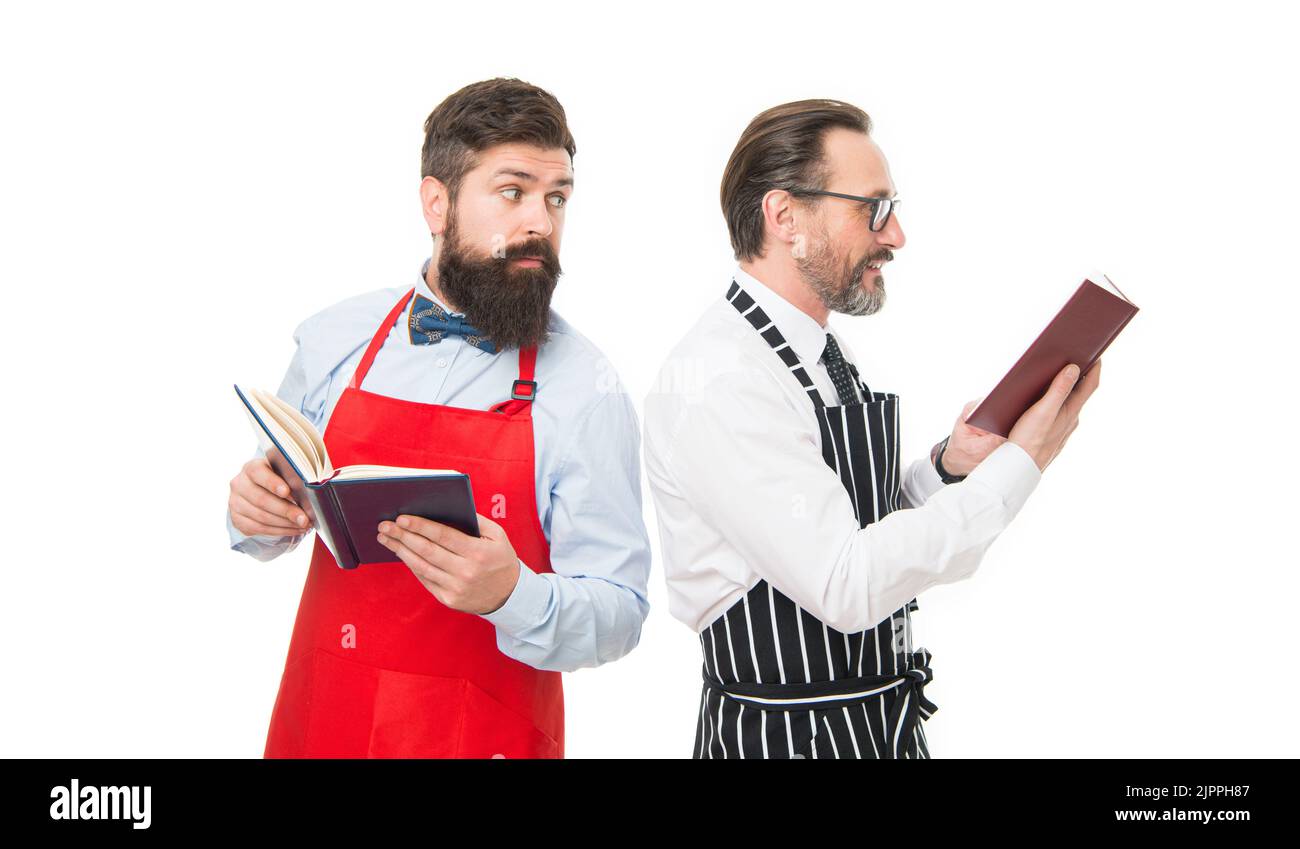 in search of better recipe. cafe and restaurant opening. bearded men with recipe book. menu planning. chef team in apron. catering business. seating Stock Photo