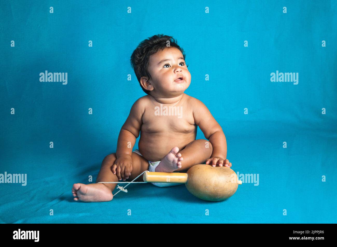 Native American baby, from the Santa Clara Pueblo with a traditional gourd rattle used for dances and ceremonies in New Mexico. Stock Photo