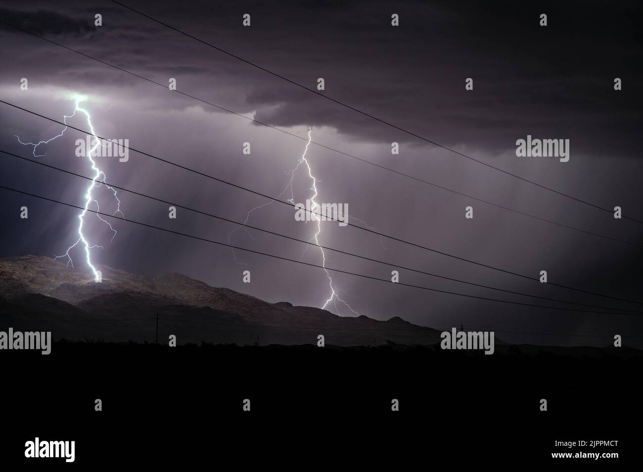 Night time lightning over mountains with power lines Stock Photo Alamy