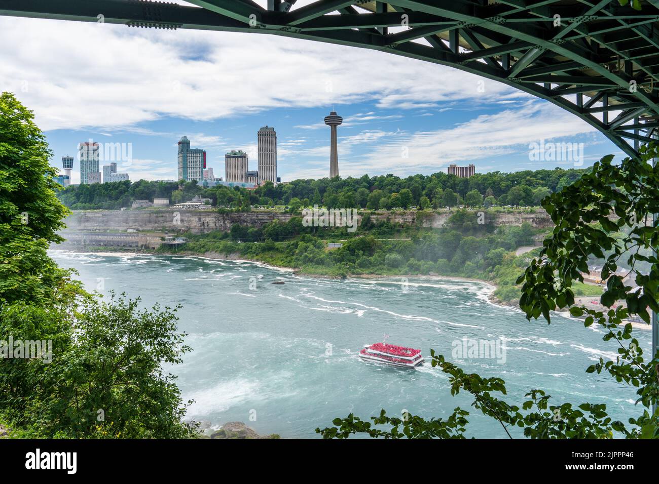 Niagara Falls, NY - July 31, 2022: Skyline of Niagara Falls, Ontario, Canada, with the Hornblower Niagara tour boat on the river below, framed by the Stock Photo