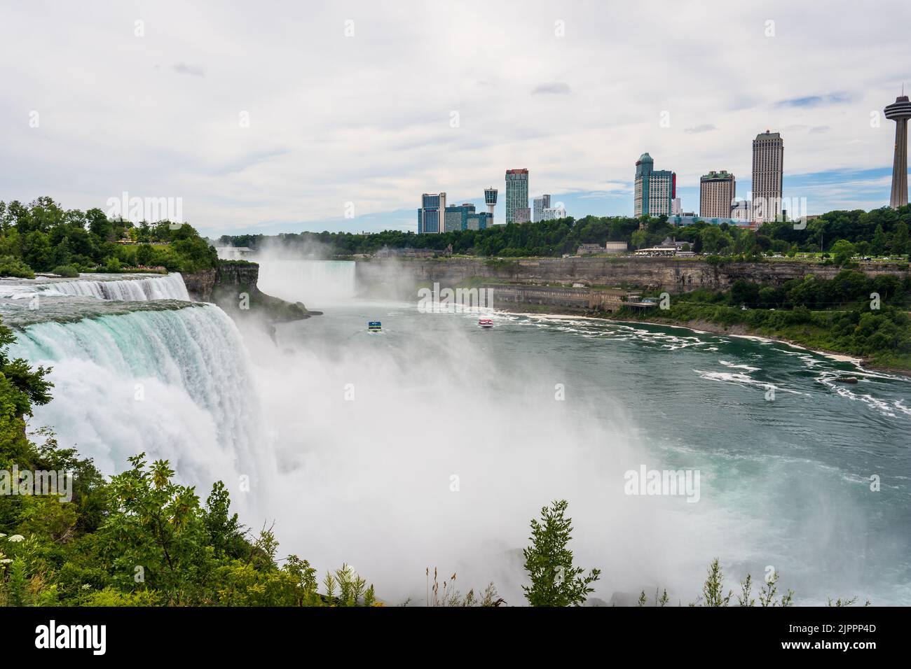 Niagara Falls, NY - July 31, 2022: Skyline of Niagara Falls, Ontario, Canada, with both the Maid of the Mist and Hornblower Niagara tour boats on the Stock Photo