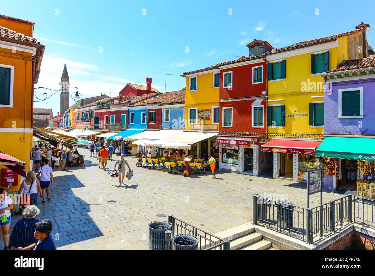 BURANO ISLAND, VENICE, ITALY - JULY 4, 2022: Tourists among the sovereign shops and restaurants on the main street of burano Island, Famous travel des Stock Photo