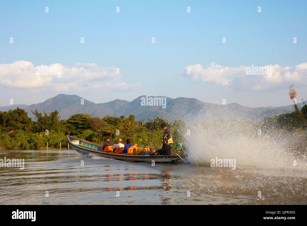 A traditional wooden boat with tourists, Inle Lake, Myanmar. Stock Photo
