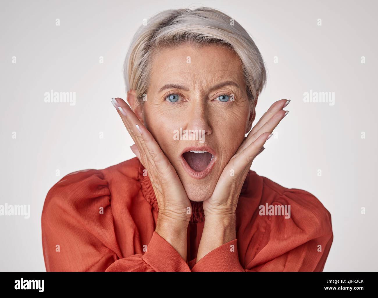 Shocked, surprised and old face of a beautiful senior woman with a wow facial expression. Portrait of an old and elderly female in shock about a Stock Photo