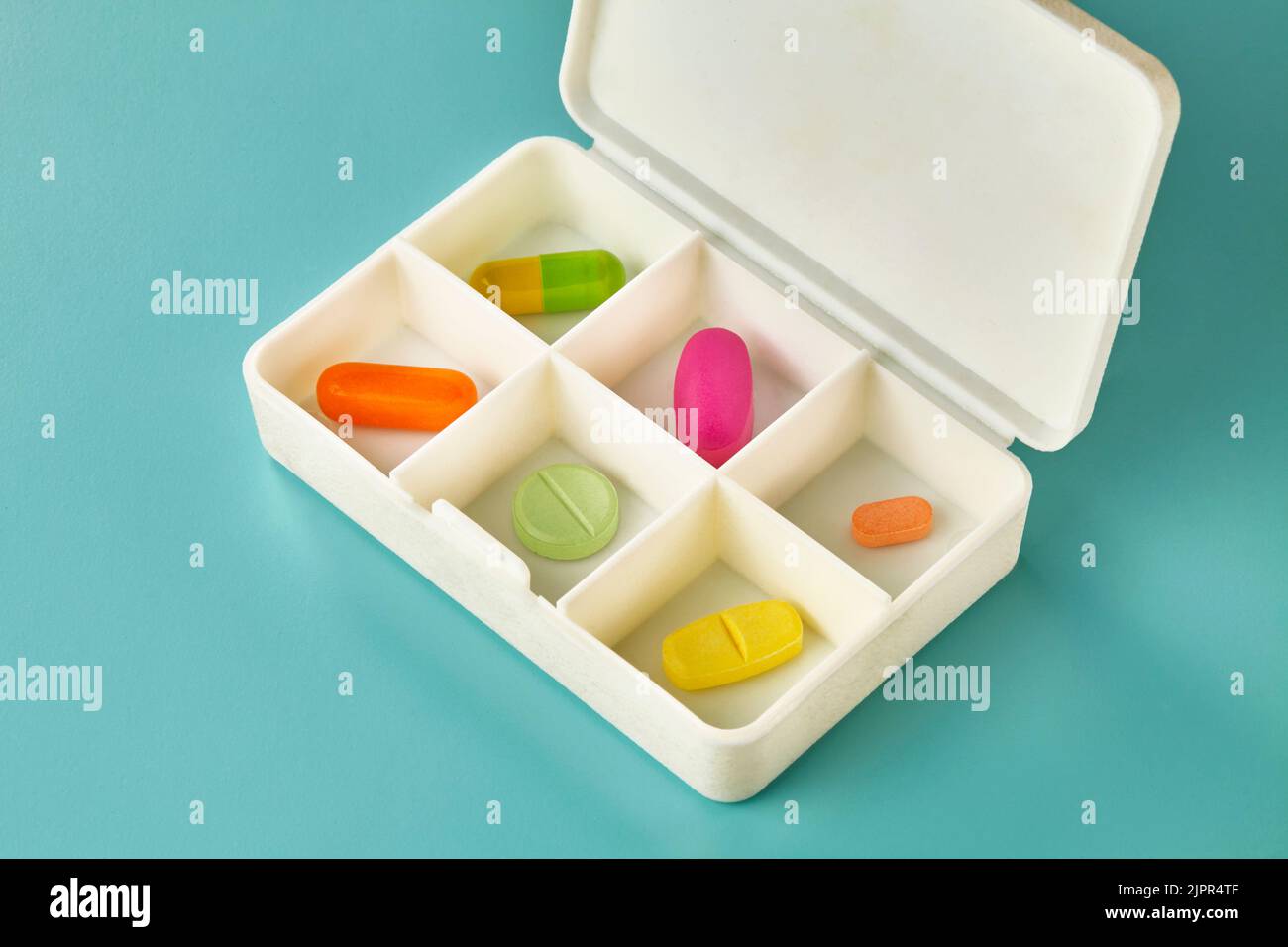 Six different coloured medicine pieces in a daily pills medicine box