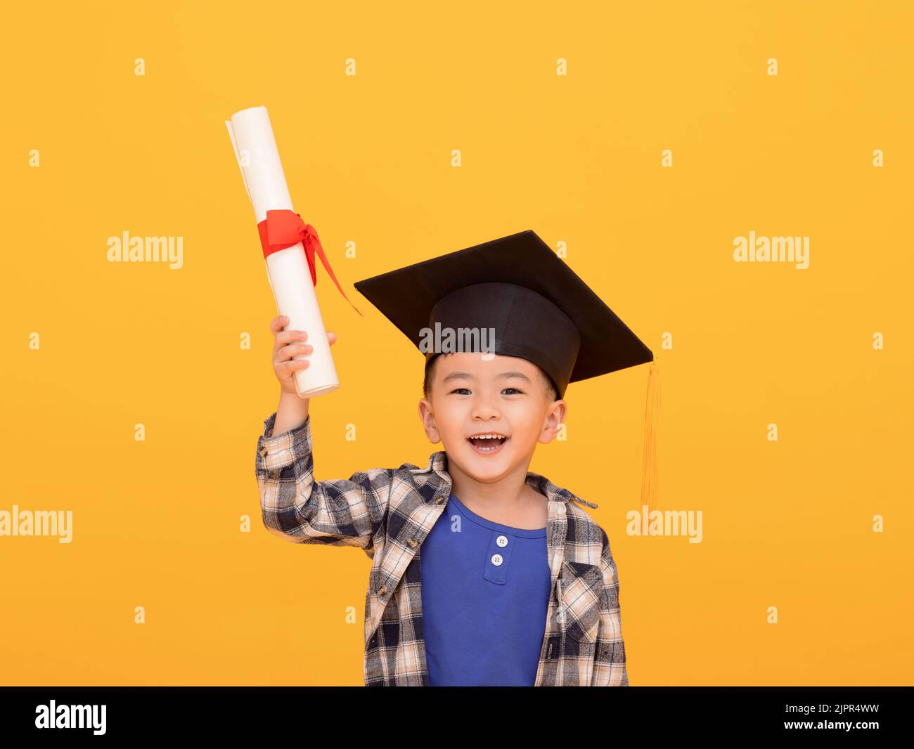 Happy Asian school kid graduate in graduation cap Stock Photo