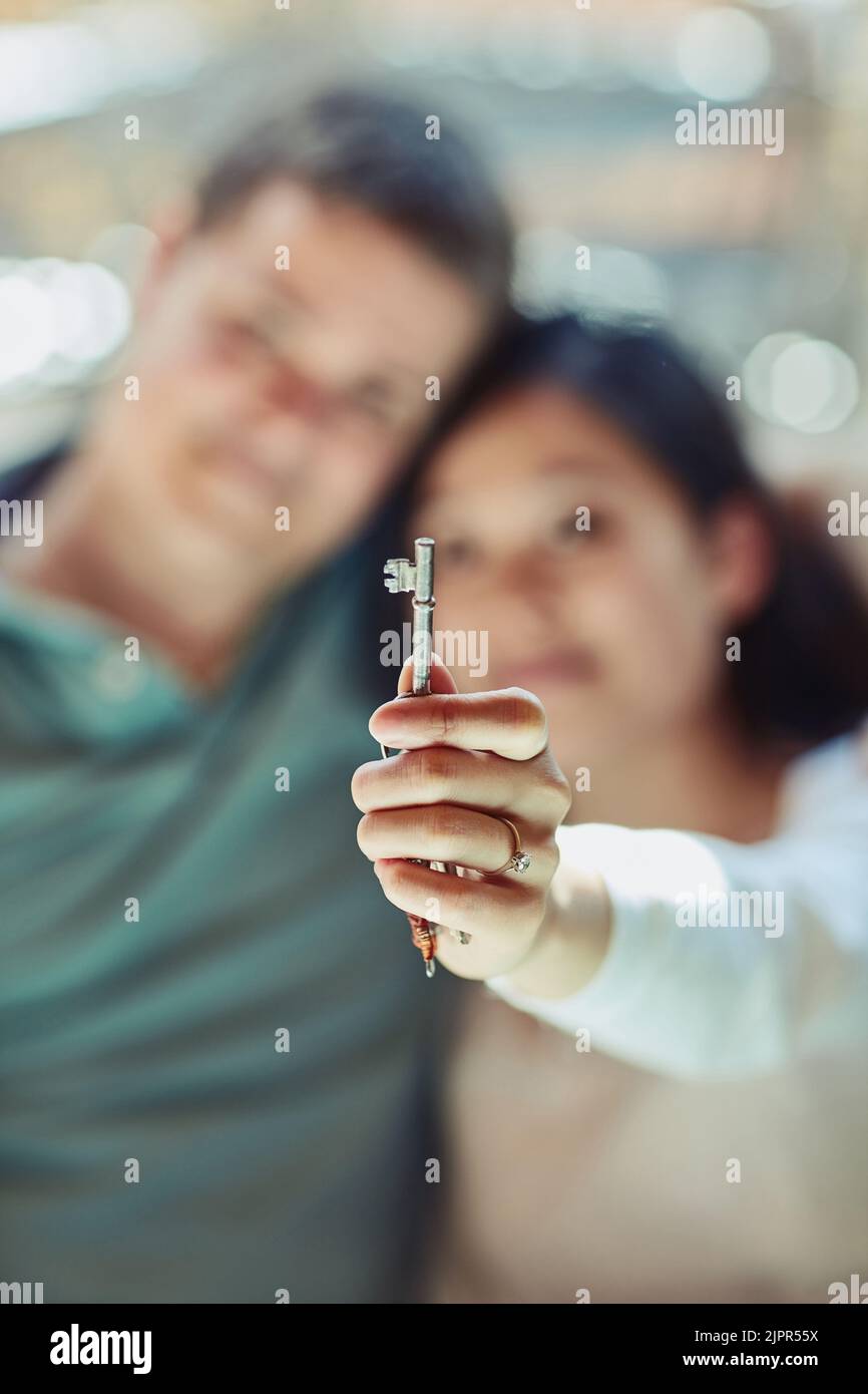 The key to happiness is love. a couple holding the keys to their home ...